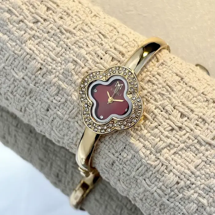 Montre-bracelet vintage en forme de trèfle à quatre feuilles pour femmes style fashion et casual avec mouvement quartz et choix de couleurs argent, blanc, or, rouge et vert