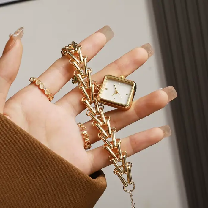 Montre de luxe dorée avec cadran triangulaire motif épi de blé