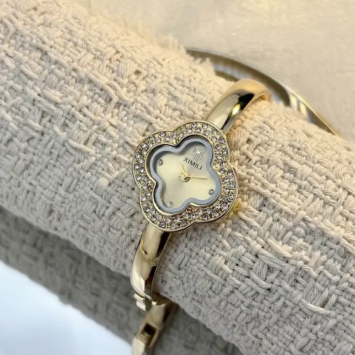 Montre-bracelet vintage en forme de trèfle à quatre feuilles pour femmes style fashion et casual avec mouvement quartz et choix de couleurs argent, blanc, or, rouge et vert