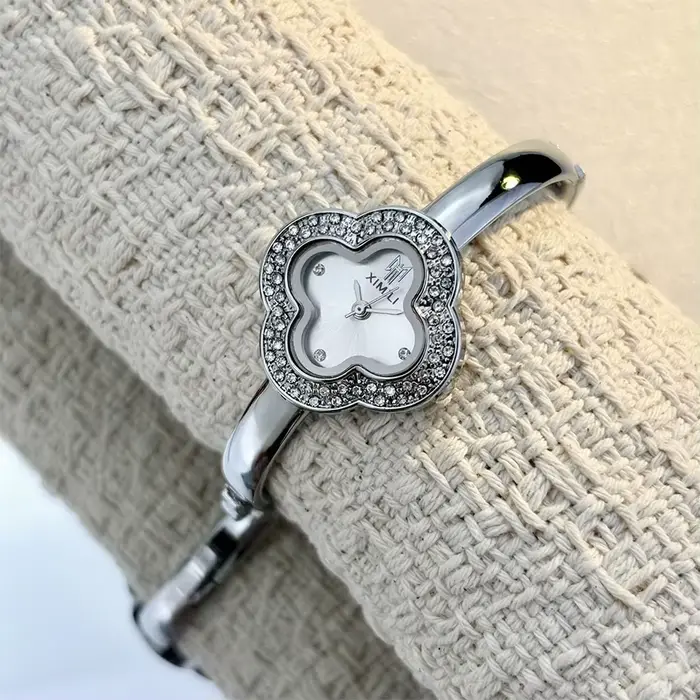 Montre-bracelet vintage en forme de trèfle à quatre feuilles pour femmes style fashion et casual avec mouvement quartz et choix de couleurs argent, blanc, or, rouge et vert