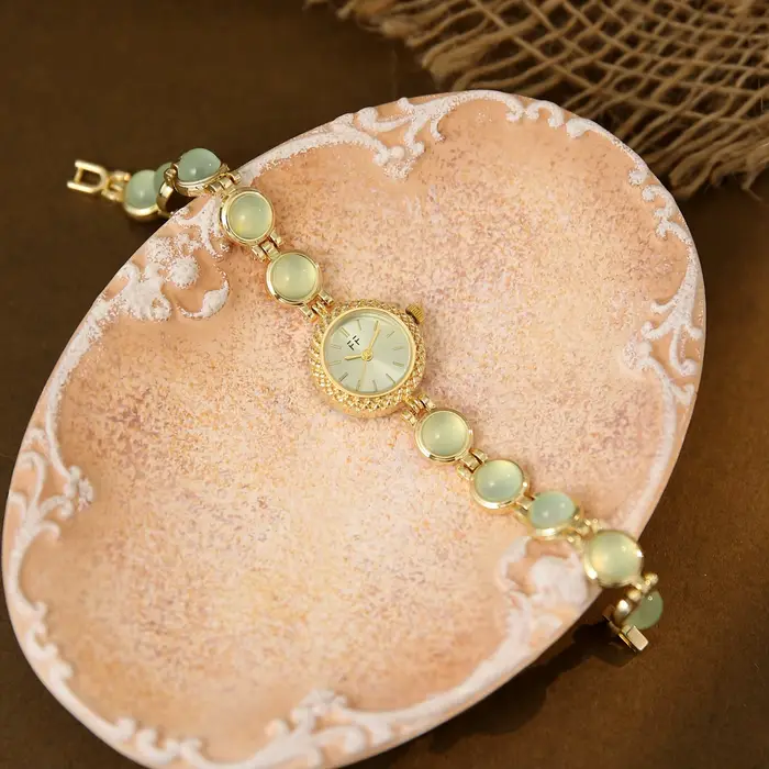 Montre vintage pour femme en or et pierres vertes