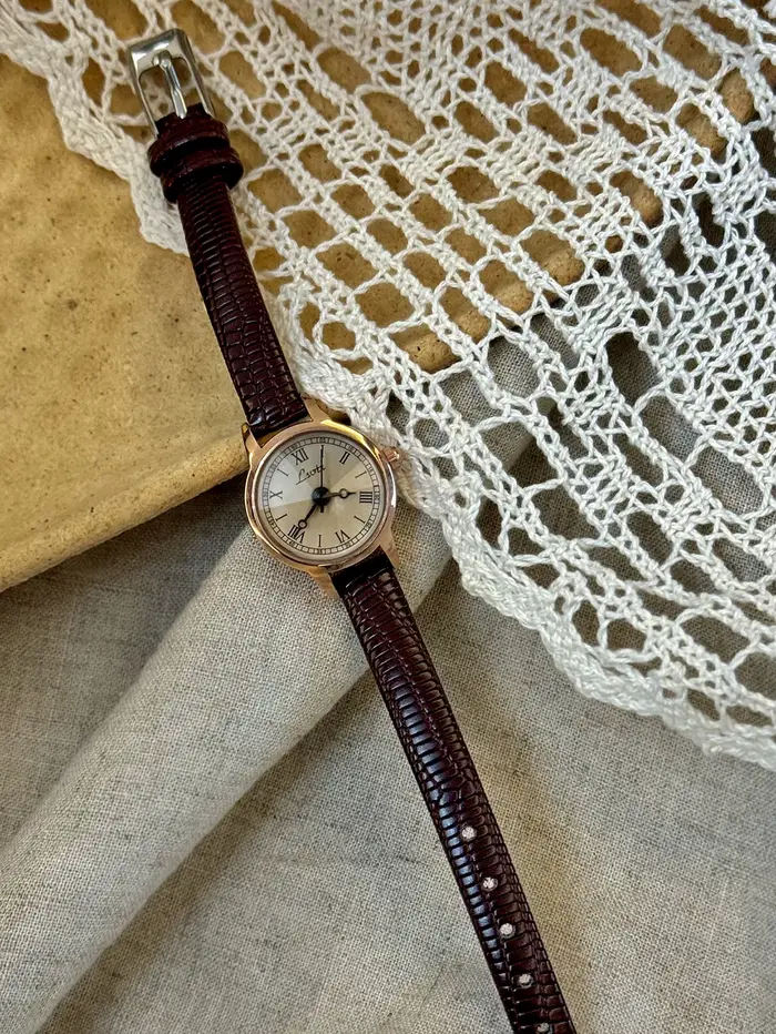 Cette montre pour femme avec bracelet en cuir couleur café de style vintage est décontractée et élégante