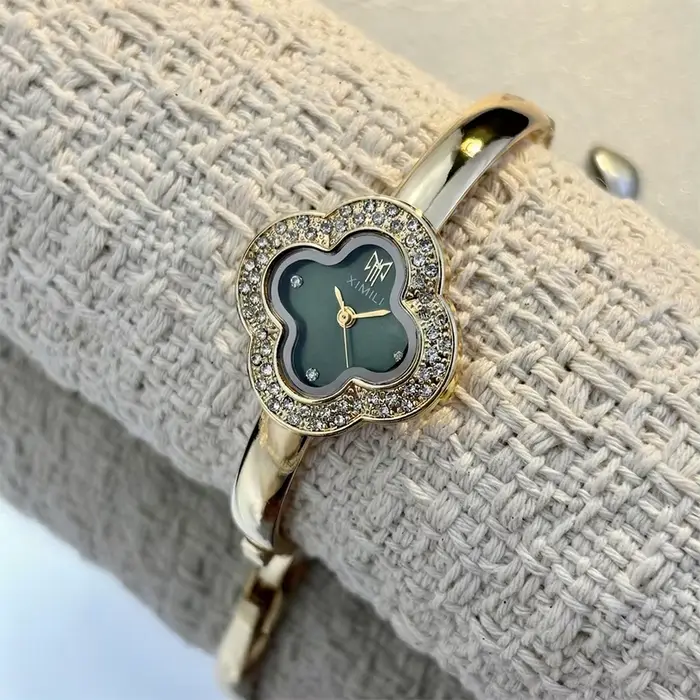 Montre-bracelet vintage en forme de trèfle à quatre feuilles pour femmes style fashion et casual avec mouvement quartz et choix de couleurs argent, blanc, or, rouge et vert