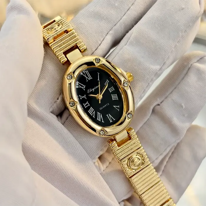 Montre dorée élégante pour femme avec cadran ovale, motifs étoiles et bracelet E-Charmed