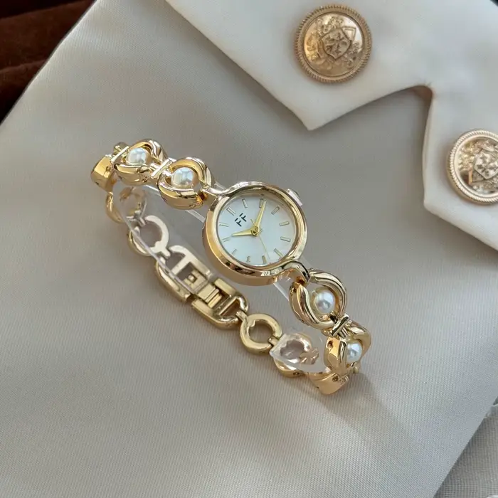Montre ronde élégante pour femmes avec pierres translucides scintillantes Nouvelles montres à quartz de luxe haut de gamme Bracelet en or Montres-bracelets