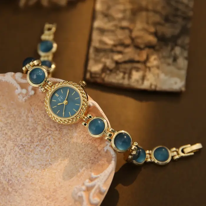 Montre vintage pour femme en or et pierres vertes