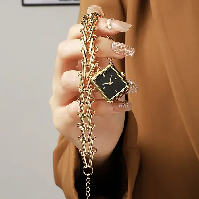Montre de luxe dorée avec cadran triangulaire motif épi de blé