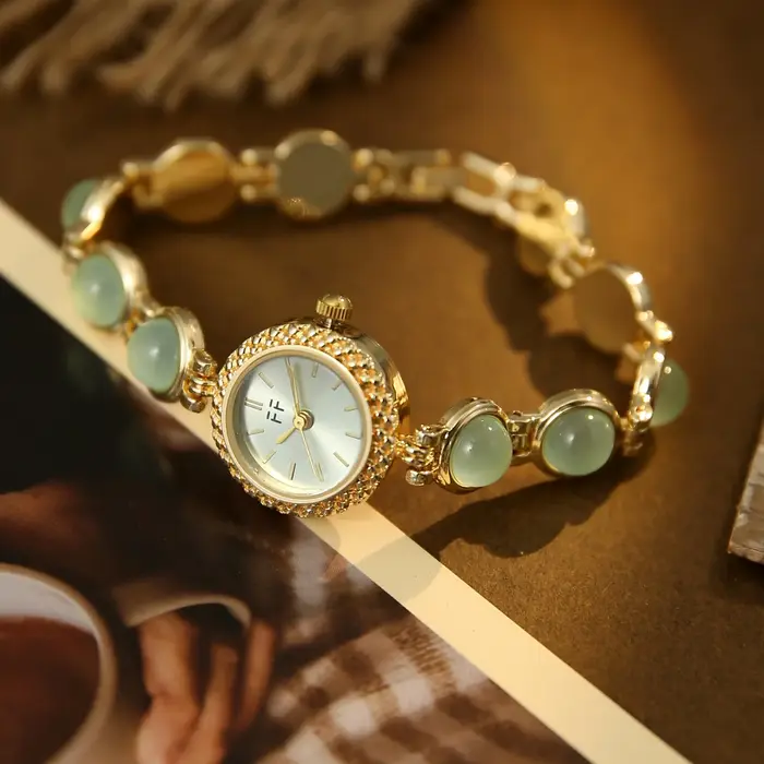 Montre vintage pour femme en or et pierres vertes