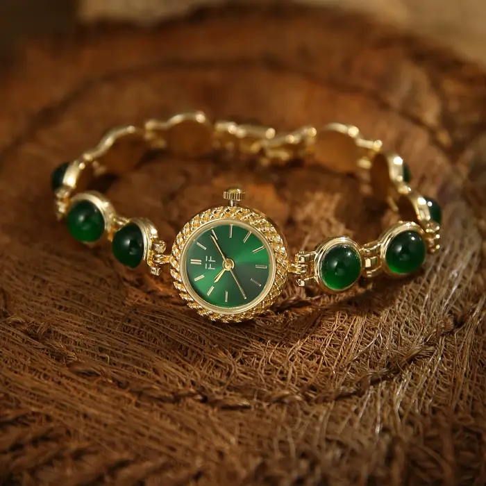 Montre vintage pour femme en or et pierres vertes