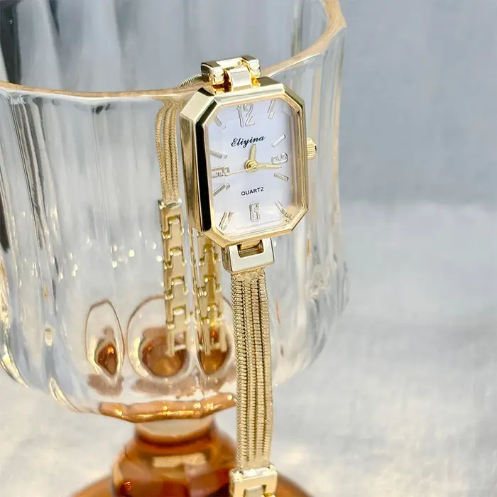 Montre-bracelet rectangulaire dorée pour femme avec chaînes à pampilles